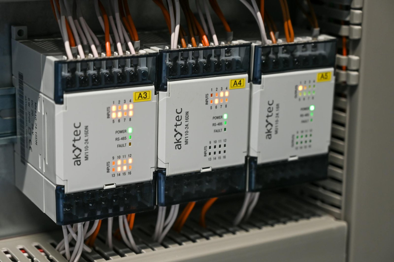 Close-up of industrial control boxes with wires and lights.