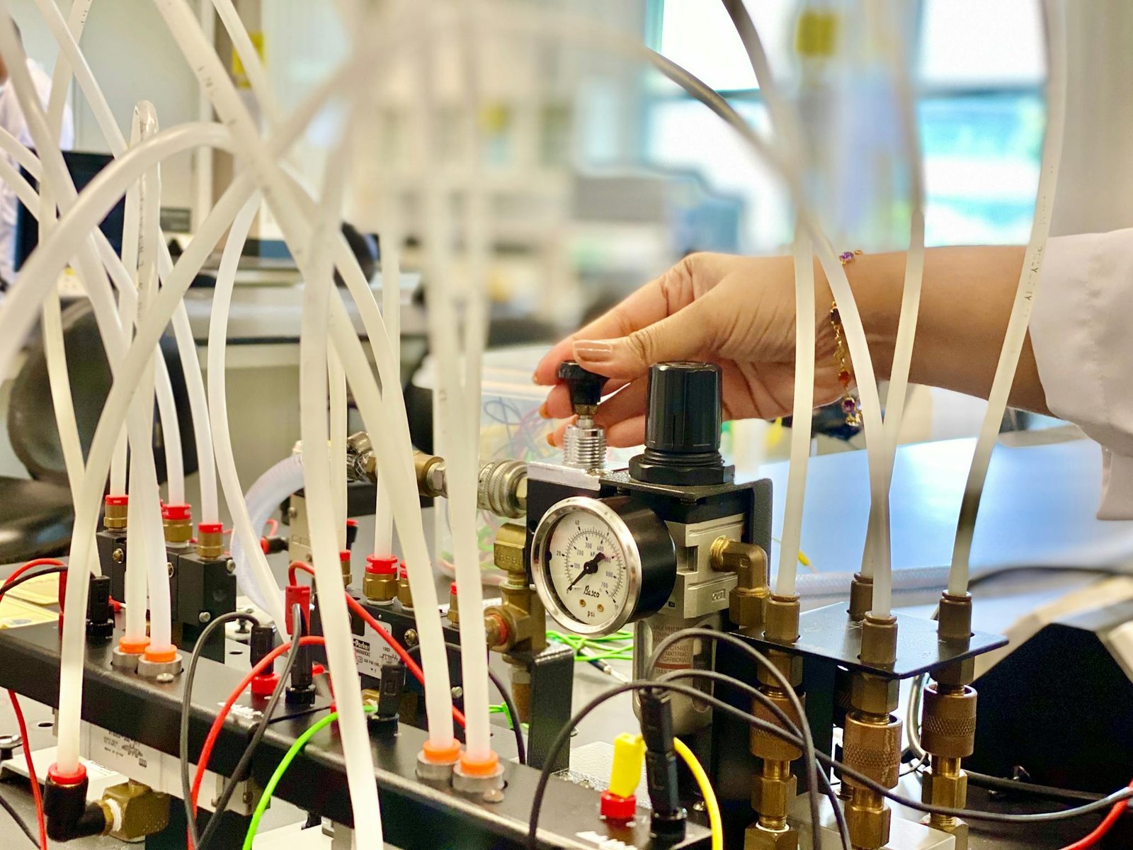 Crop female laboratory worker pressing pump lever in modern lab during working process